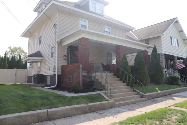 view of front of property with a front yard, a porch, and central air condition unit