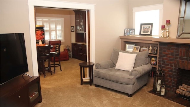 living area with light colored carpet and a fireplace