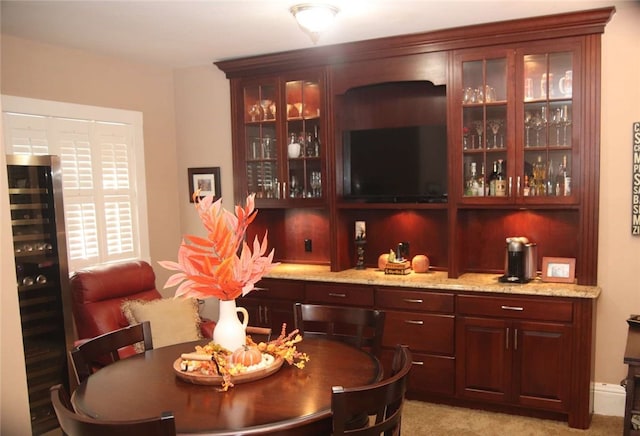 bar with light stone countertops, light carpet, and wine cooler