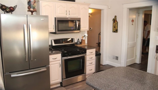 kitchen with white cabinets, stainless steel appliances, and dark wood-type flooring