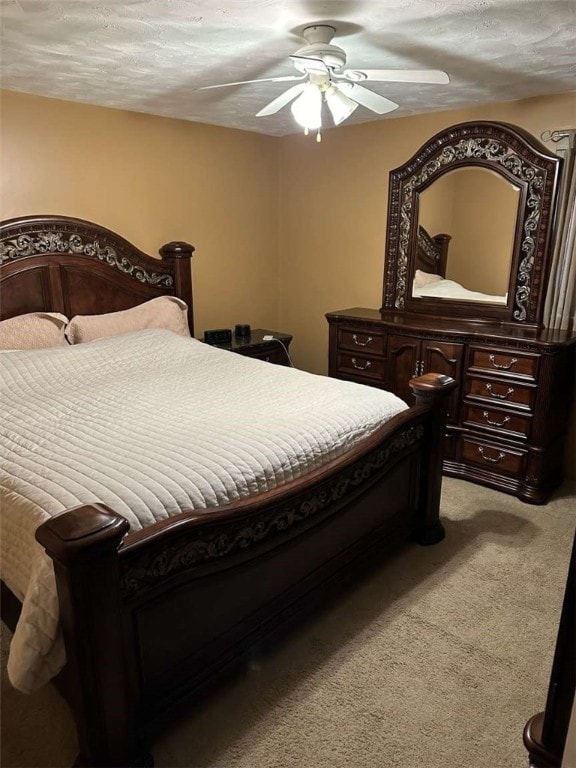 carpeted bedroom with ceiling fan and a textured ceiling