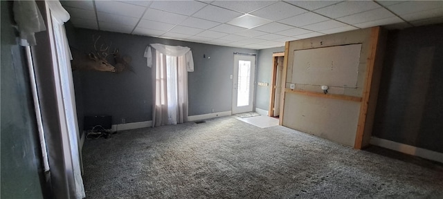 carpeted empty room with a drop ceiling