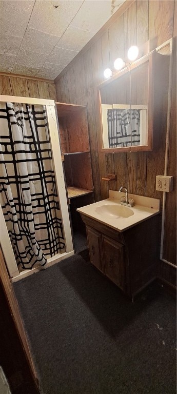 bathroom with vanity and wood walls