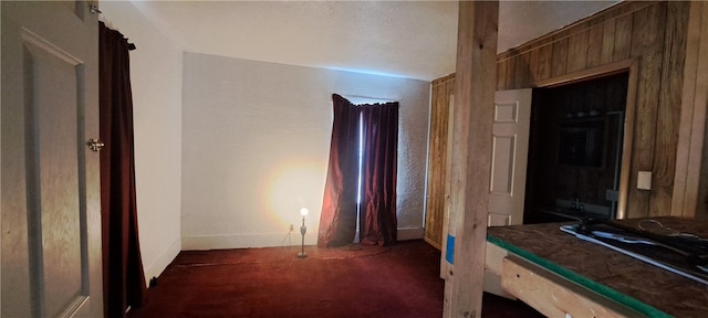 carpeted bedroom with wooden walls