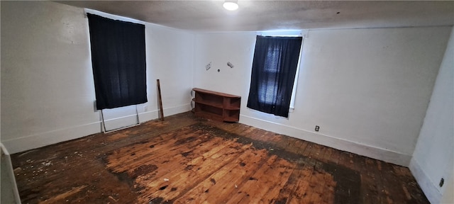 empty room with dark hardwood / wood-style flooring