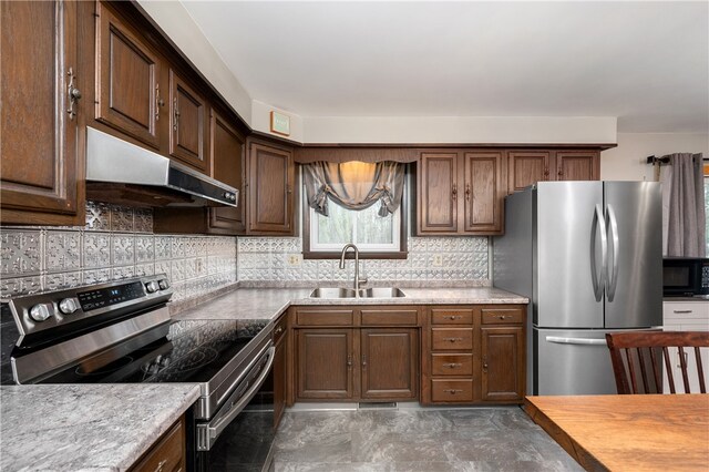 kitchen with tasteful backsplash, sink, dark brown cabinets, and appliances with stainless steel finishes