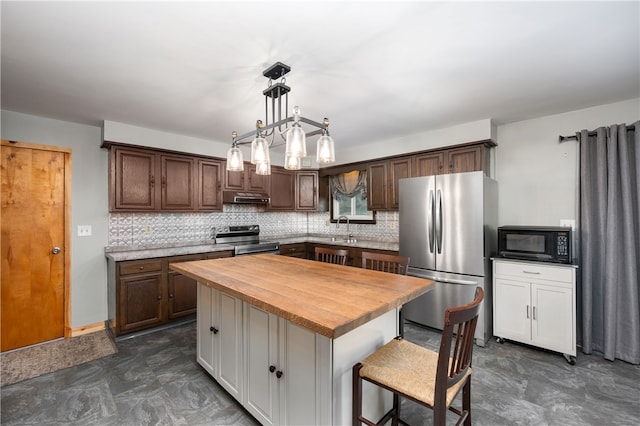 kitchen with a center island, exhaust hood, tasteful backsplash, butcher block countertops, and stainless steel appliances