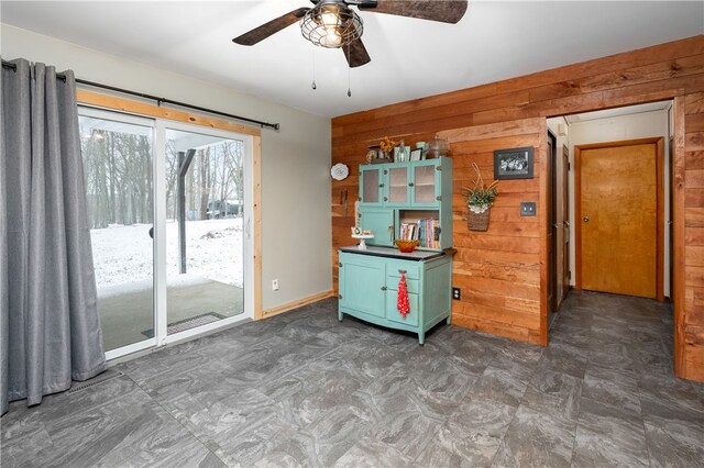 kitchen featuring wood walls and ceiling fan