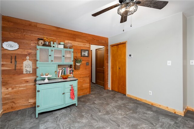 kitchen featuring wooden walls and ceiling fan