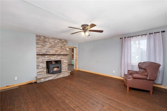 unfurnished living room with a wood stove, ceiling fan, and dark wood-type flooring