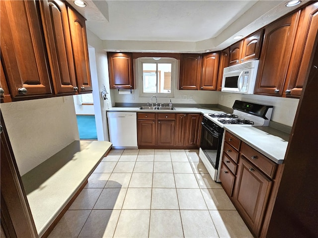 kitchen with light tile patterned flooring, white appliances, and sink