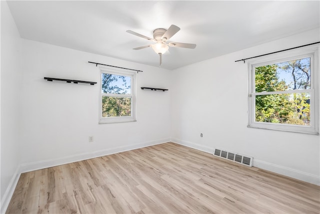 spare room with light hardwood / wood-style flooring, plenty of natural light, and ceiling fan