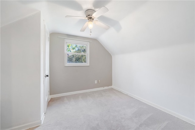 additional living space with light carpet, ceiling fan, and vaulted ceiling