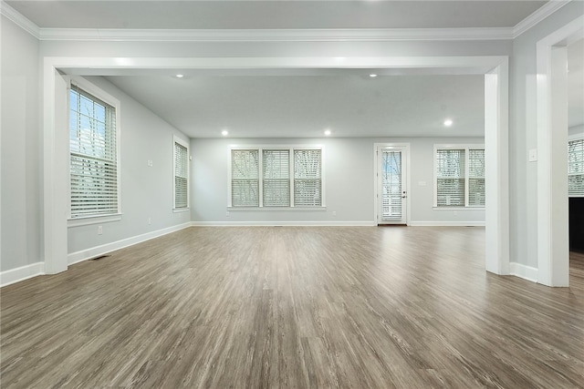 unfurnished living room featuring dark wood-type flooring and ornamental molding