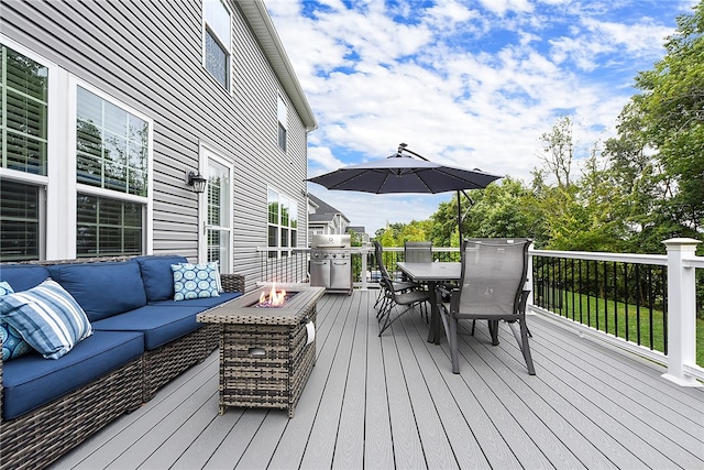 wooden terrace featuring an outdoor living space with a fire pit