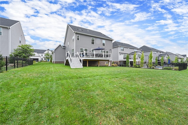 back of property featuring a lawn and a deck