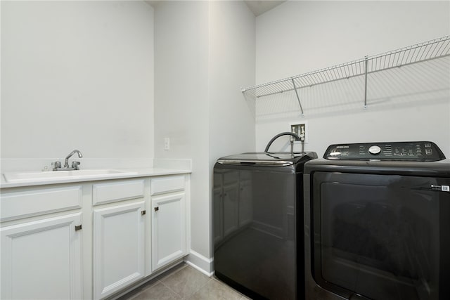 laundry room featuring cabinets, sink, light tile patterned floors, and washer and dryer