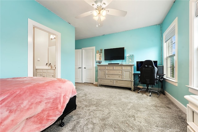 bedroom featuring light colored carpet, ceiling fan, and ensuite bathroom