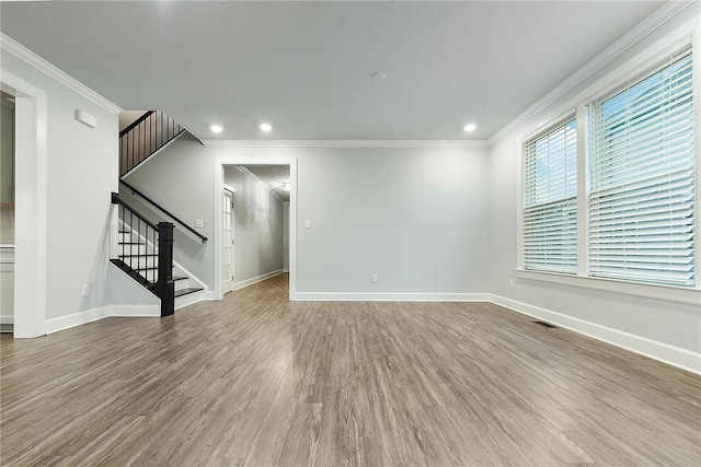 unfurnished living room with hardwood / wood-style flooring and crown molding