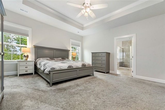 bedroom with carpet flooring, ceiling fan, ornamental molding, connected bathroom, and a tray ceiling