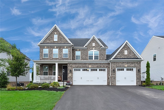 craftsman-style house featuring covered porch, a garage, and a front yard