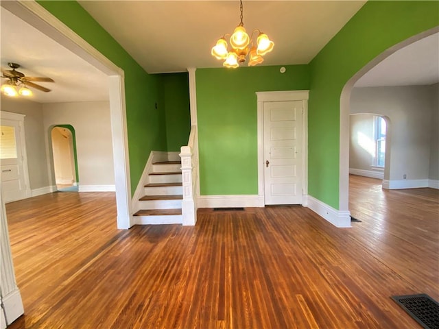 spare room featuring hardwood / wood-style flooring and ceiling fan with notable chandelier