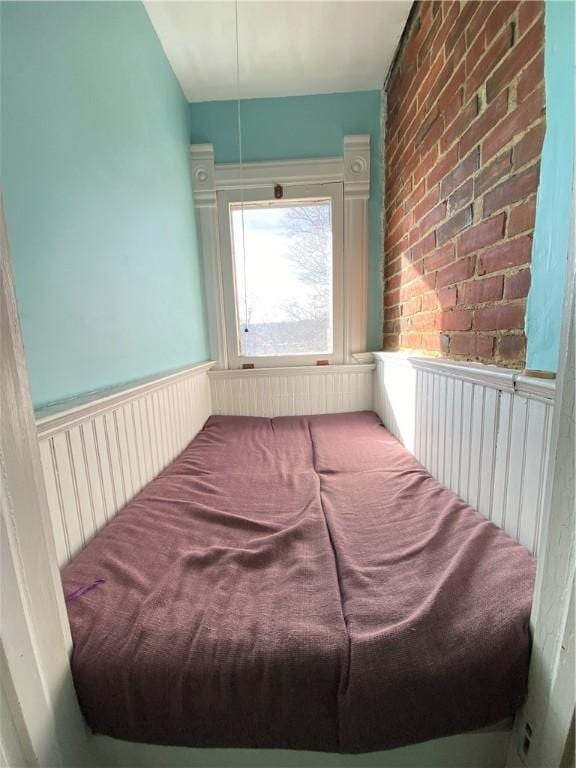 bedroom featuring brick wall