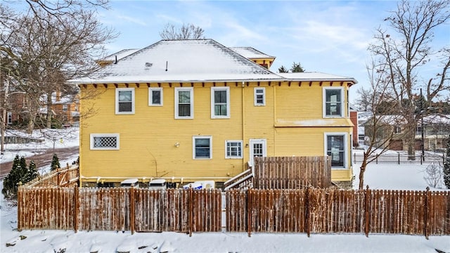 view of snow covered rear of property