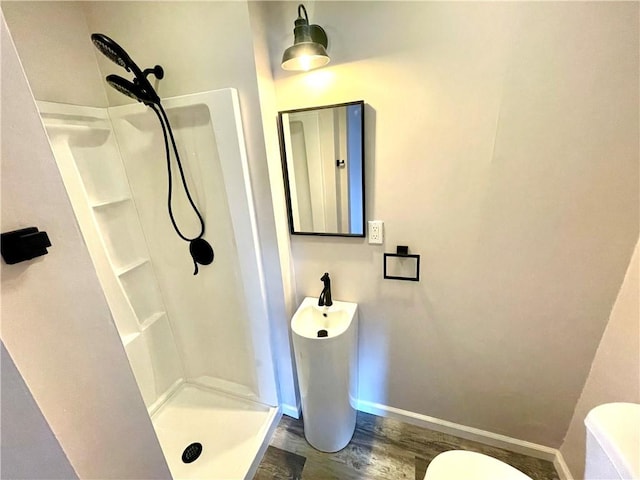 bathroom with toilet, wood-type flooring, and walk in shower