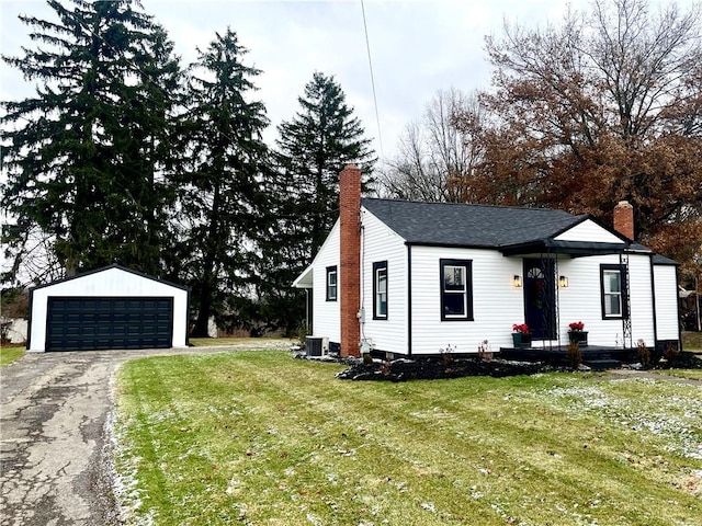 view of front of property with a garage, an outdoor structure, a front yard, and central air condition unit