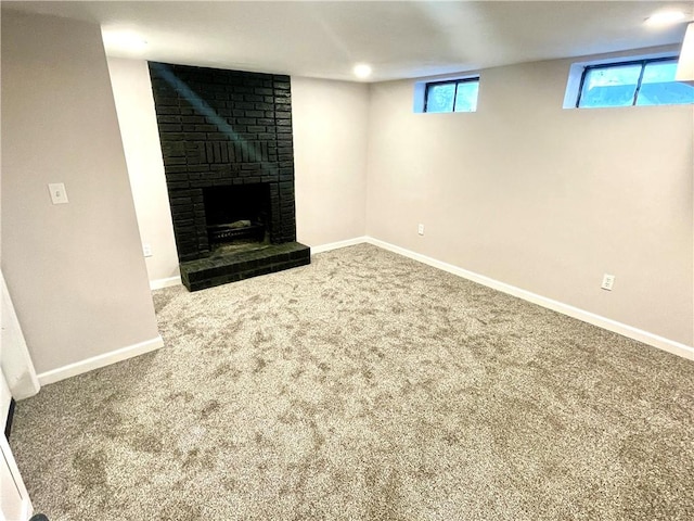 basement featuring carpet and a brick fireplace