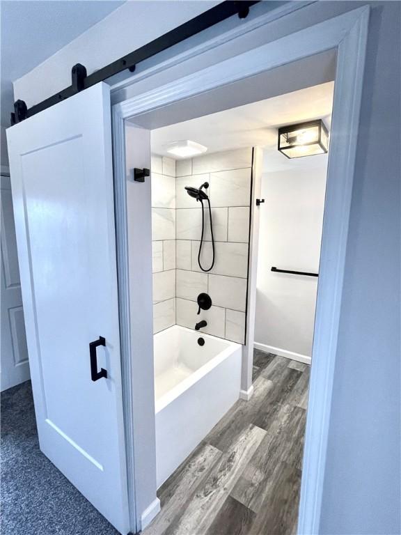 bathroom featuring hardwood / wood-style floors and tiled shower / bath combo