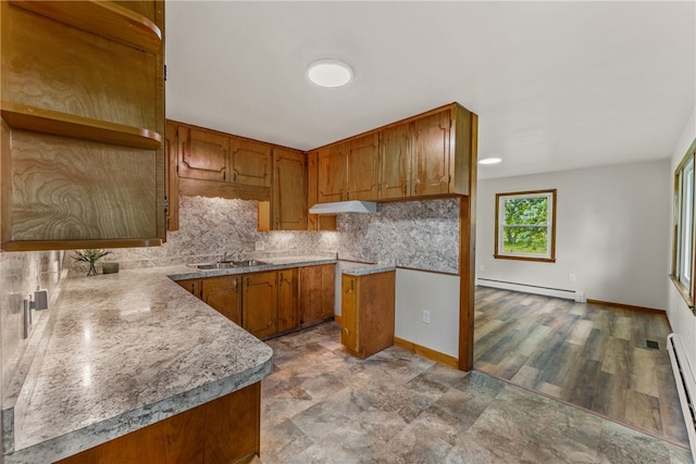 kitchen featuring decorative backsplash, sink, a baseboard radiator, and light hardwood / wood-style floors