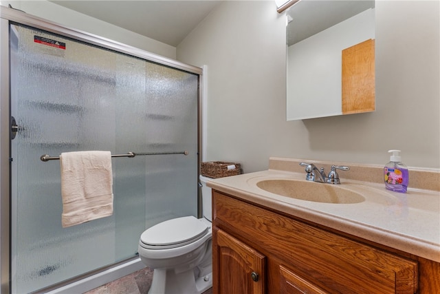 bathroom with a shower with door, vanity, and toilet