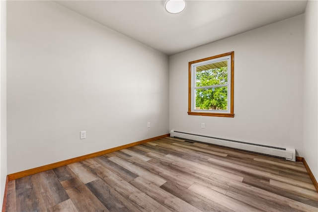 unfurnished room with hardwood / wood-style floors and a baseboard radiator