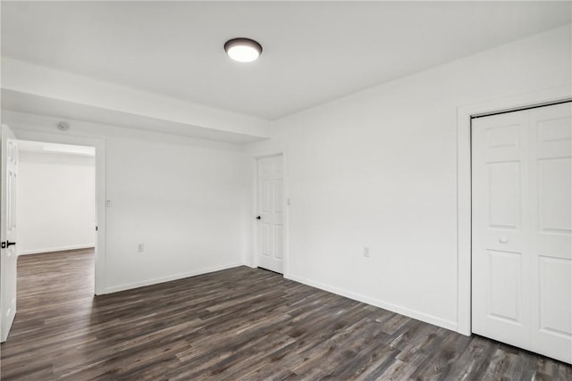 unfurnished bedroom featuring a closet and dark wood-type flooring