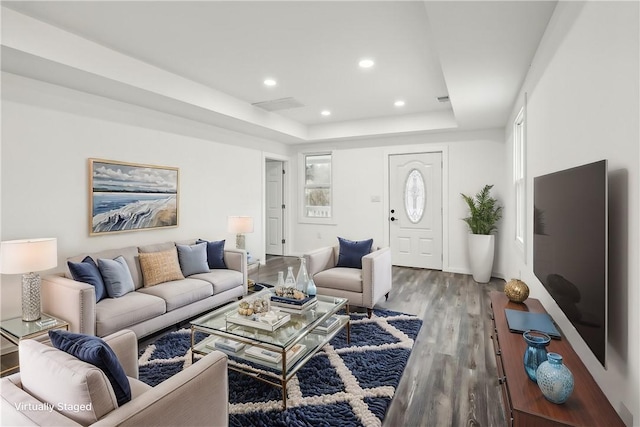 living room with a tray ceiling and hardwood / wood-style floors