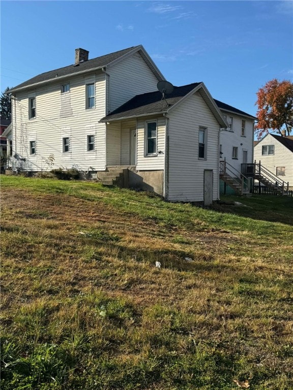 rear view of house featuring a yard