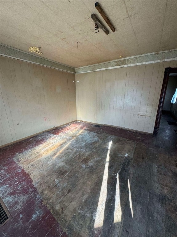 empty room with dark wood-type flooring and wood walls