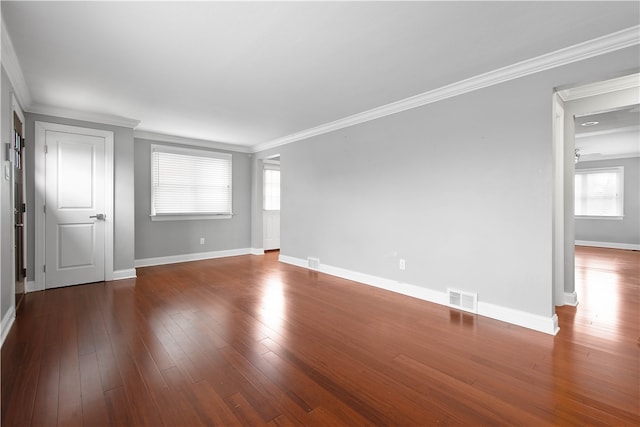 empty room featuring dark hardwood / wood-style floors, a healthy amount of sunlight, and crown molding