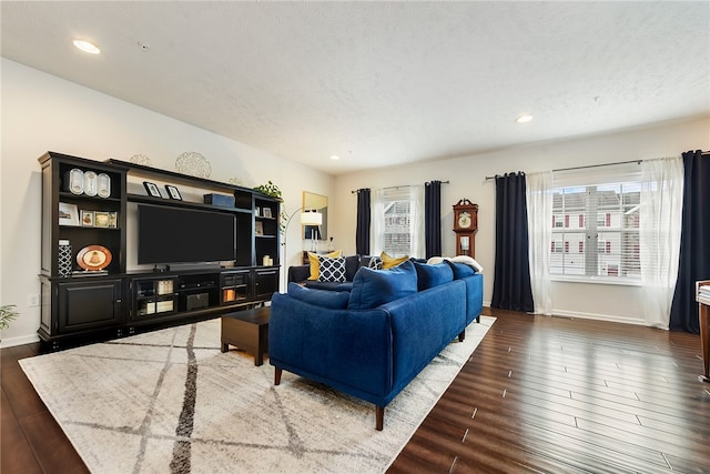 living room with a textured ceiling and dark hardwood / wood-style floors