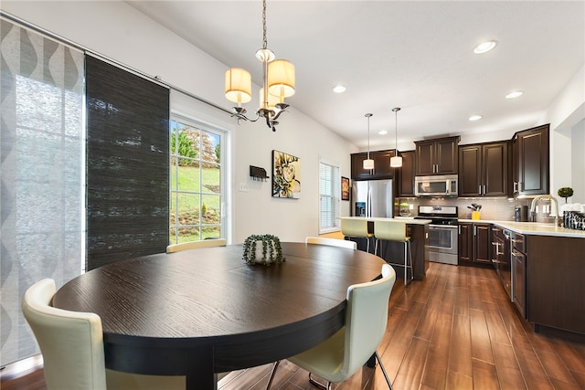 dining space with a chandelier, dark wood-type flooring, and sink