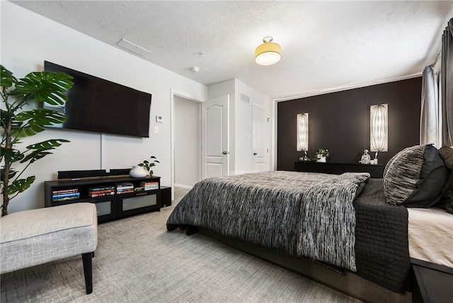 bedroom with a textured ceiling and light carpet