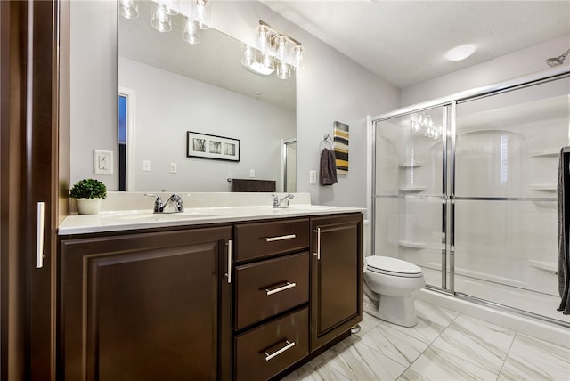 bathroom with a textured ceiling, vanity, toilet, and an enclosed shower