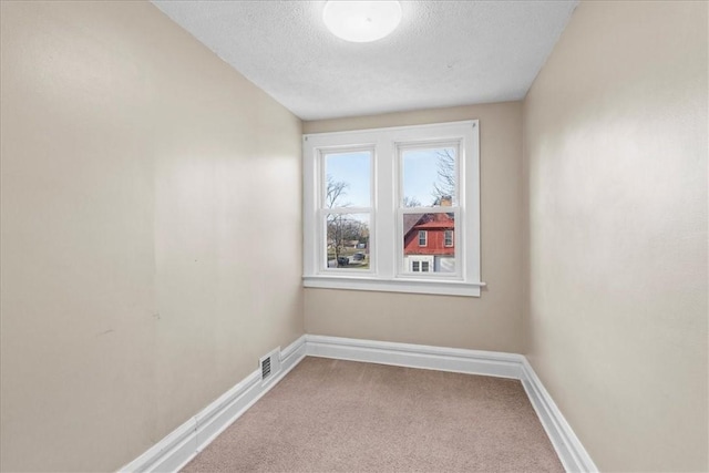 unfurnished room featuring carpet floors and a textured ceiling