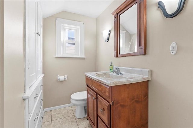 bathroom with tile patterned flooring, vanity, toilet, and lofted ceiling