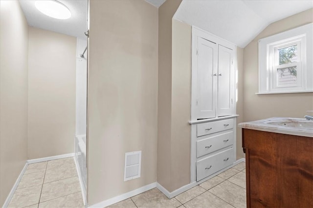 bathroom with vanity, shower / bath combination, tile patterned floors, and lofted ceiling