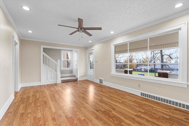 interior space with light wood-type flooring, ornamental molding, a textured ceiling, ceiling fan, and a baseboard radiator