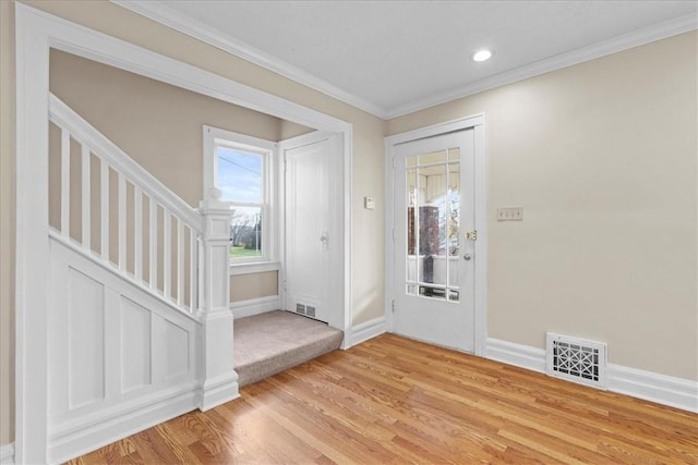 entrance foyer with crown molding and light hardwood / wood-style flooring