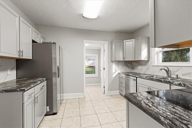 kitchen with plenty of natural light, sink, decorative backsplash, and stainless steel appliances